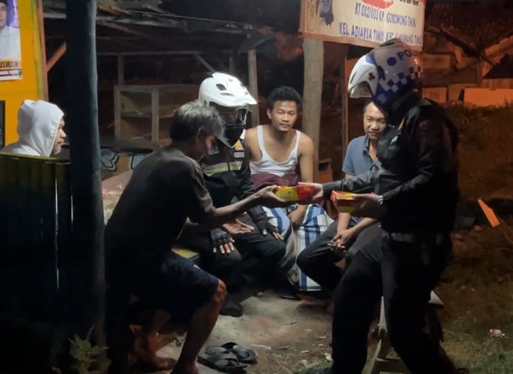 Anggota Polres Karawang membagikan nasi untuk sahur warga. (Foto: Humas)