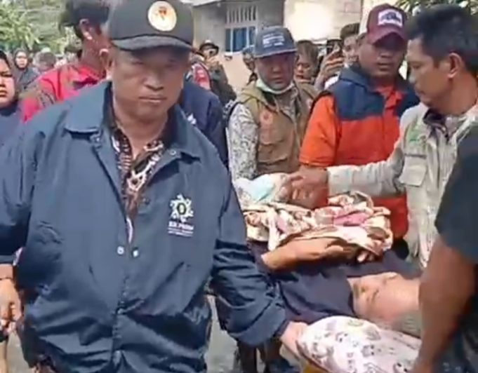 Camat Kutawaluya Evakuasi Lansia Sakit Korban Banjir di Desa Sindangmukti Camat Kutawaluya, Karta Wijaya evakuasi lansia korban banjir. (AlexaPodcast.ID)